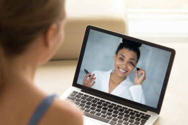 woman looking at online beauty tutorial on her laptop