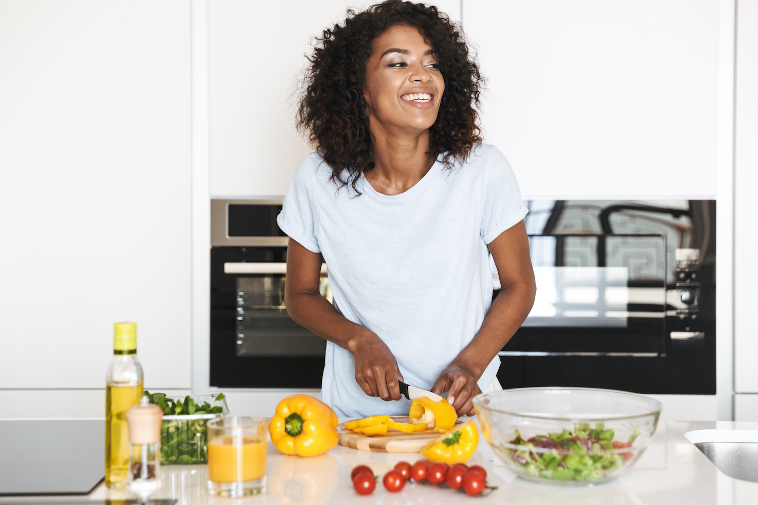 laughing woman preparing healthy food in her kitchen